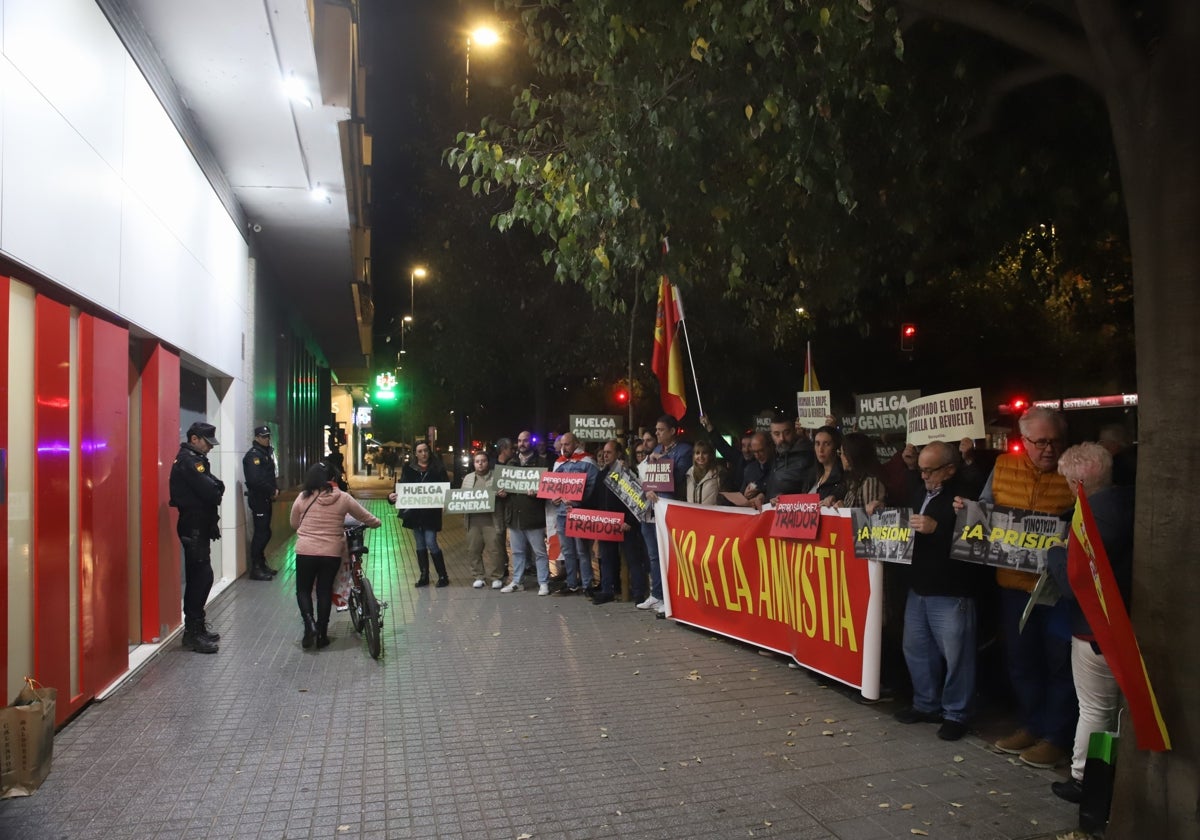 Los asistentes a la protesta ante la sede del PSOE de Córdoba, con policías en la puerta