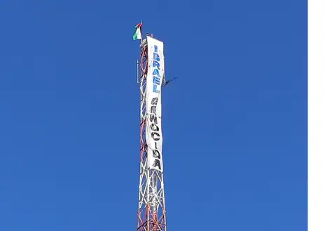 Imagen secundaria 1 - Cuelgan una bandera de Palestina y una pancarta frente a la embajada de Israel en Madrid