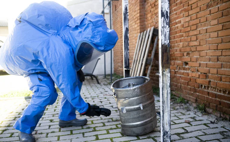 Imagen principal - Un policía, con el traje de protección, se acerca a un bidón en el que hay material bioquímico. Dos compañeros ayudan a vestirse a un Tedax antes de acudir a desactivar un explosivo. Y una agente controla el robot del Tedax a distancia