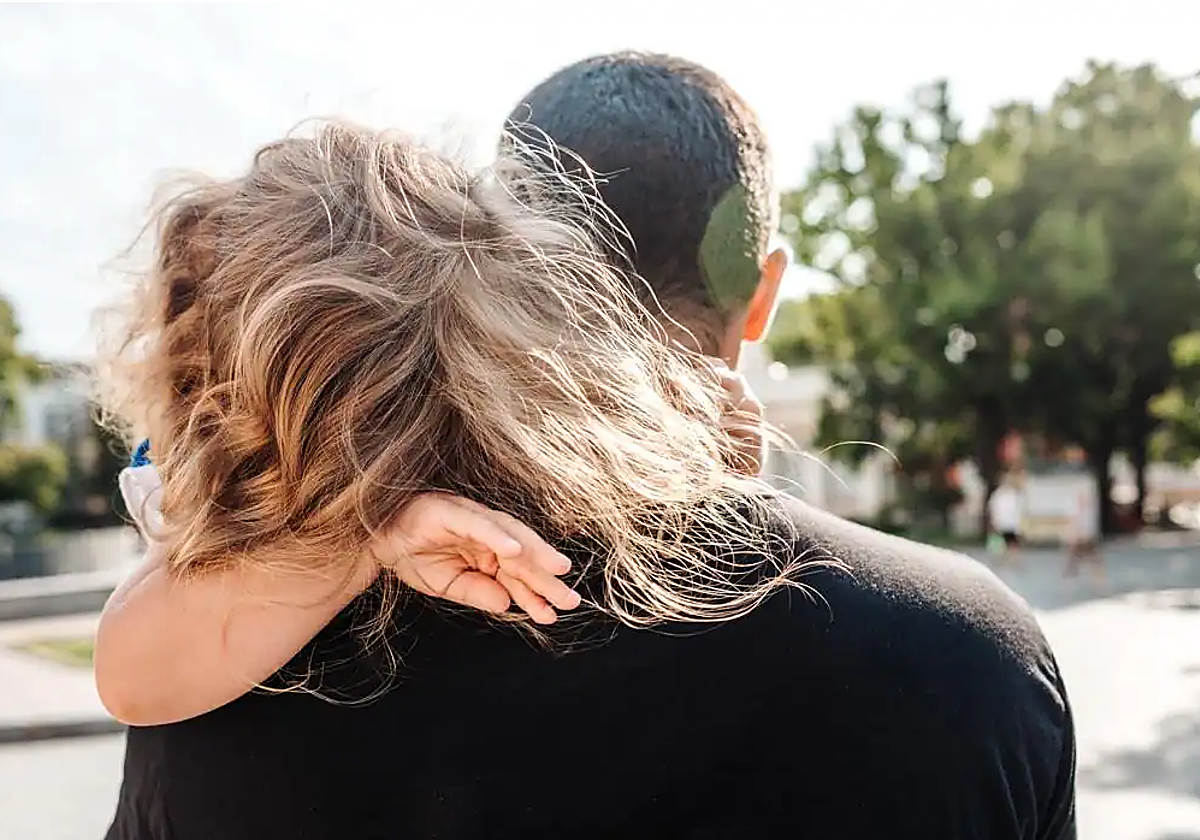 Imagen de archivo de un padre con su hija en brazos