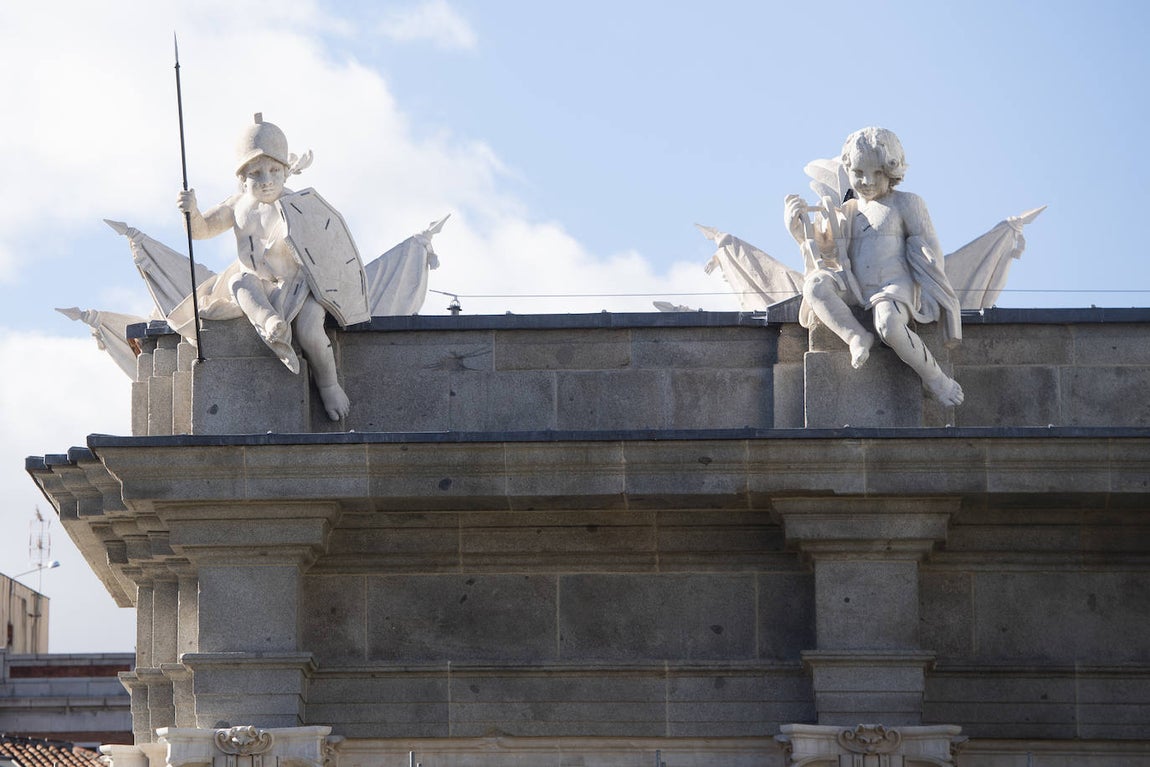 Las virtudes de la Fortaleza y la Templanza, en el costado sur del frontón oriental, descubiertos tras 16 meses de intervención. El resto de la Puerta de Alcalá se desprenderá de la lona y los andamios progresivamente y, previsiblemente, se inaugurará antes de Nochebuena.