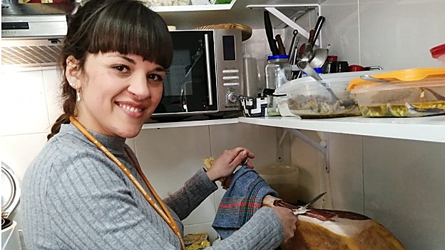 La empresaria, enfrascada cortando jamón en la cocina del bar El Torrejón
