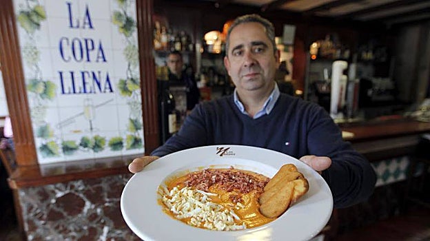 El propietario de Casa Antonio muetra uno de los platos de su cocina junto a la Cruz de Juárez