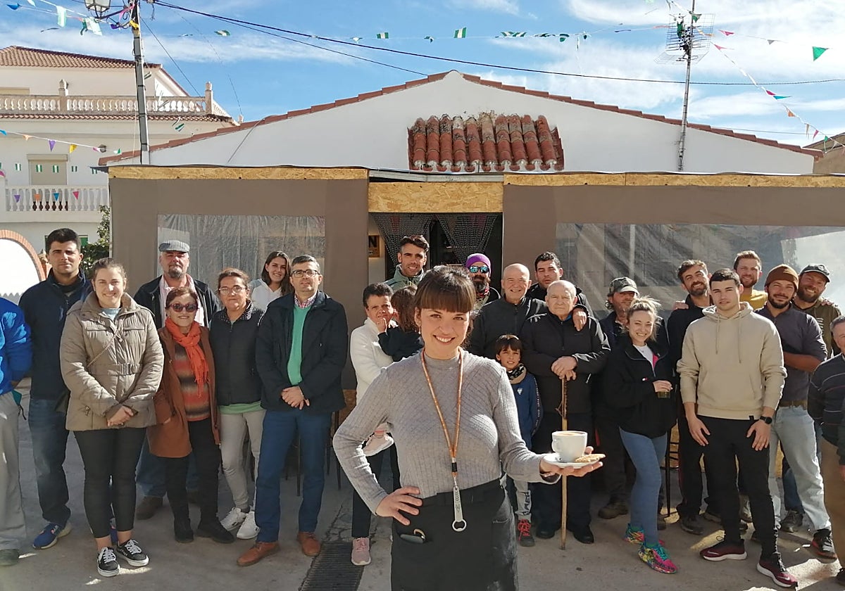 Noelia Ortega, ante la fachada del bar Torrejón, en Yátor, y detrás la clientela habitual