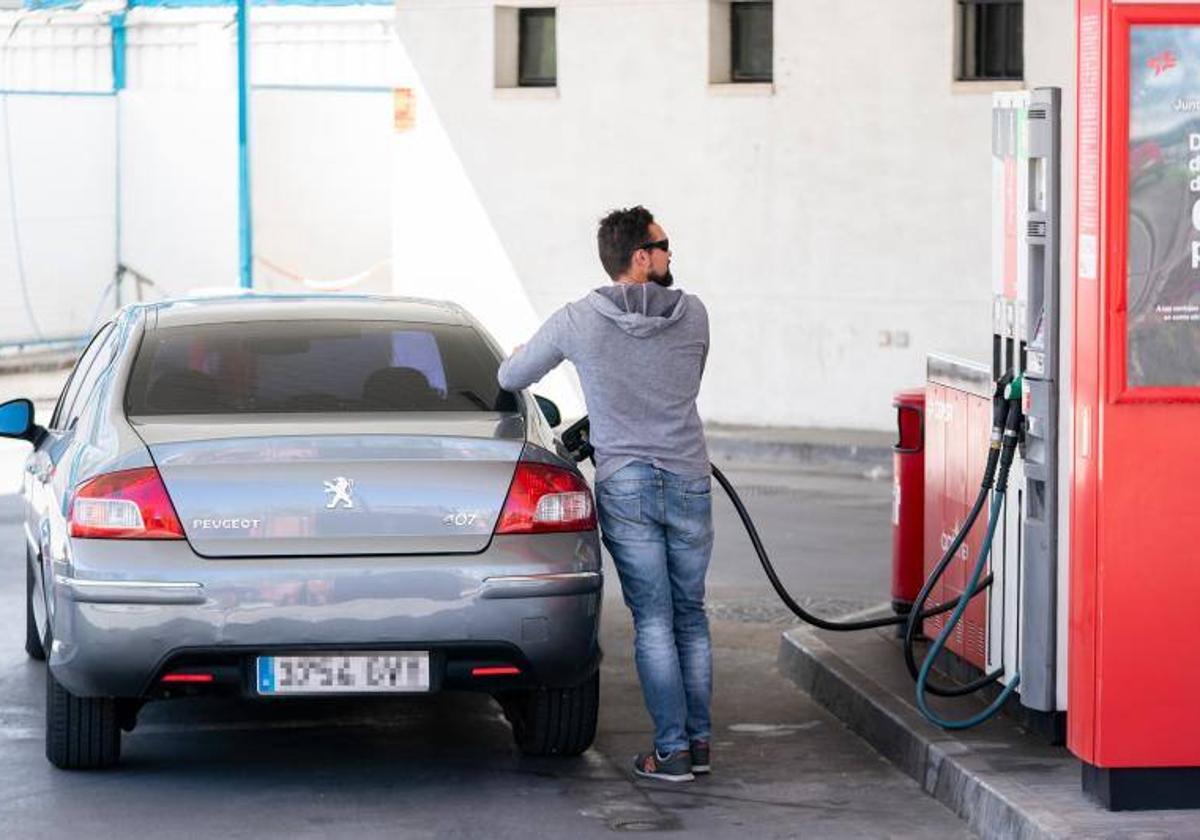 Un joven repostando en una gasolinera