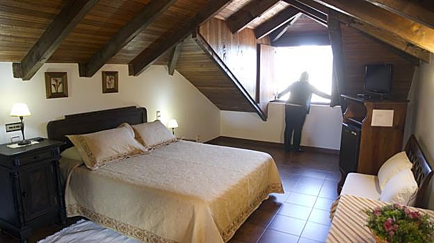 Una turista abre una ventana en la casa rural en la que se aloja