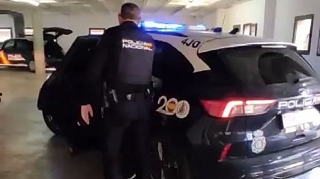 Un agente custodia a uno de los detenidos por los disparos en Orihuela.