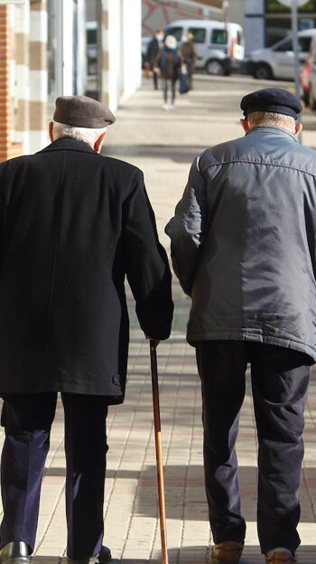 Dos ancianos pasean por una calle de Ponferrada. Foto de archivo