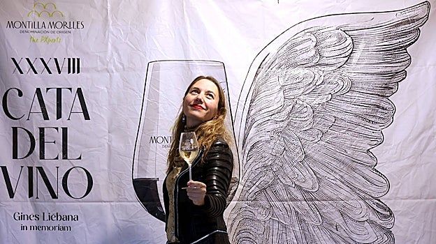 Mara de Miguel posa con una copa ante el cartel de la Cata del Vino de 2023