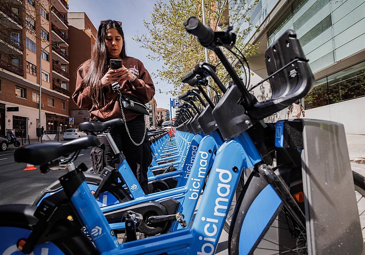 Una usuaria utiliza Bicimad, en una estación de Nuevos Ministerios