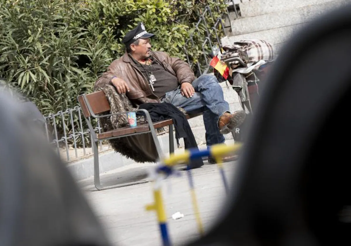 Un hombre sintecho, en un banco del centro de Madrid