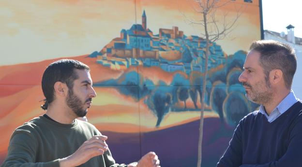 El autor charla con el alcalde de Castro del Río, ante el mural