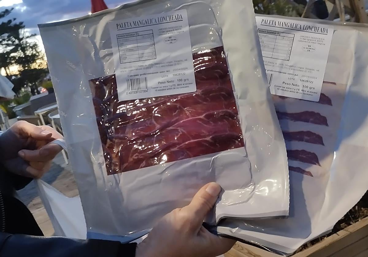 Una mujer muestra sobres de jamón lanzados en la Cabalgata de La Carlota