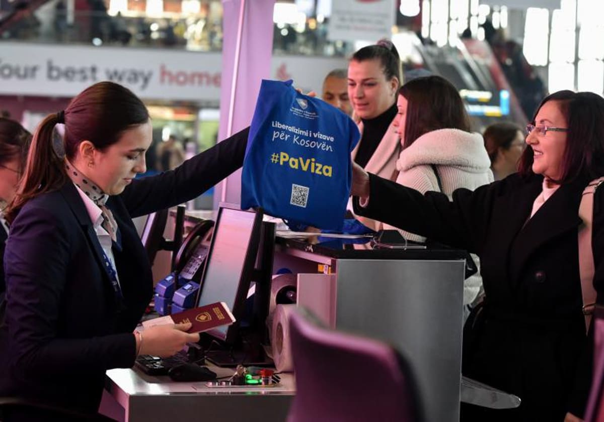 Personal de aduanas recibe de un viajero una bolsa donde se puede leer «sin visado»