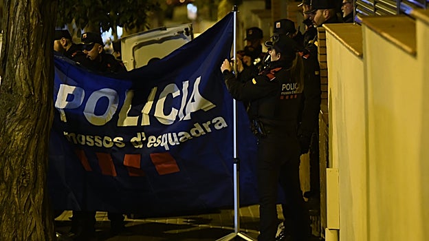 Los Mossos colocan una lona para el traslado de los cadáveres