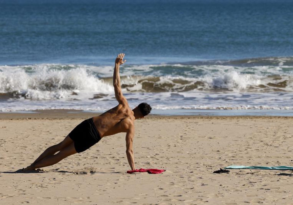 Una persona practica deporte en la playa de la Malvarrosa de Valencia