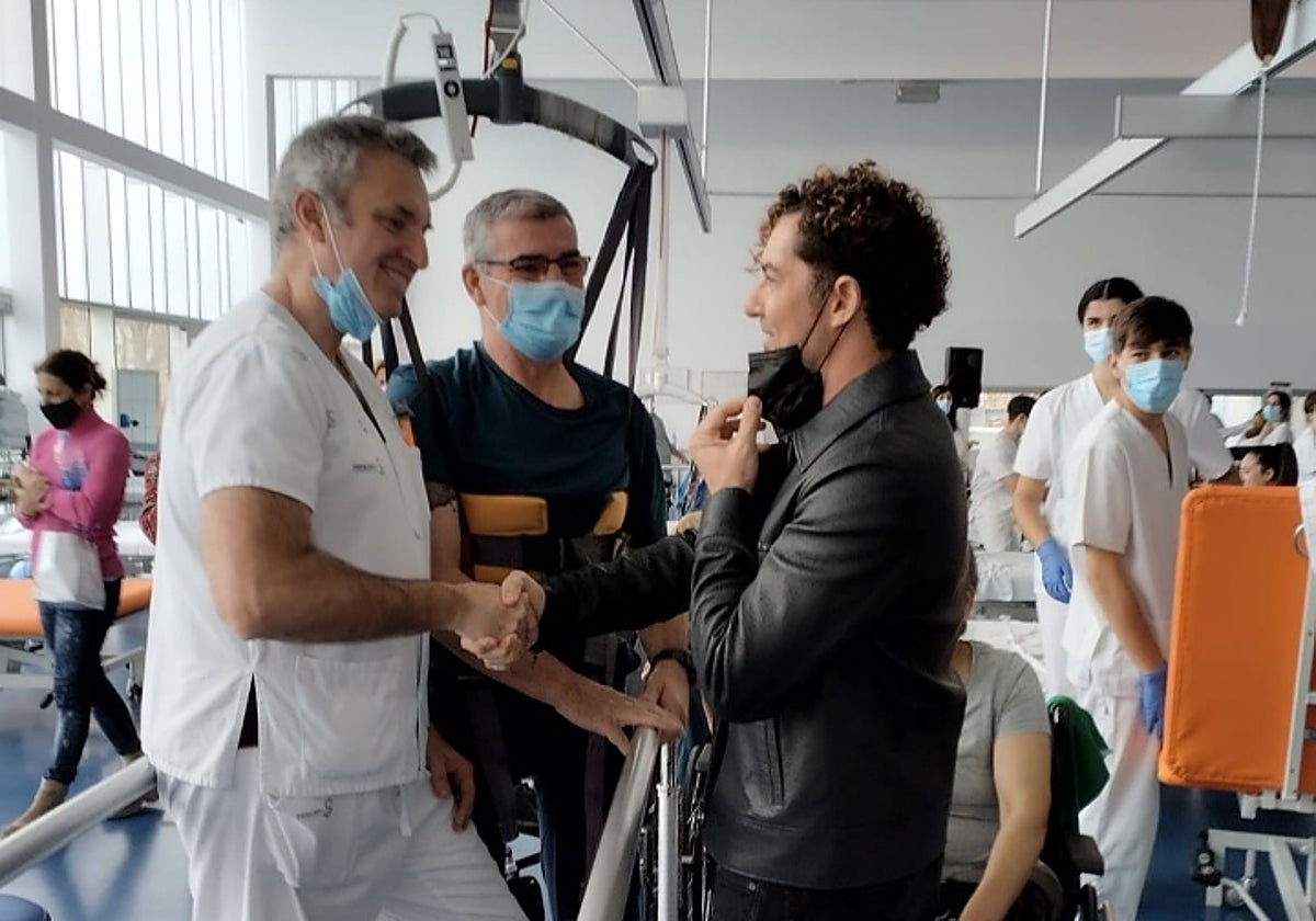 José Luis y David Bisbal se estrechan la mano esta tarde mientras el cantante se baja la mascarilla