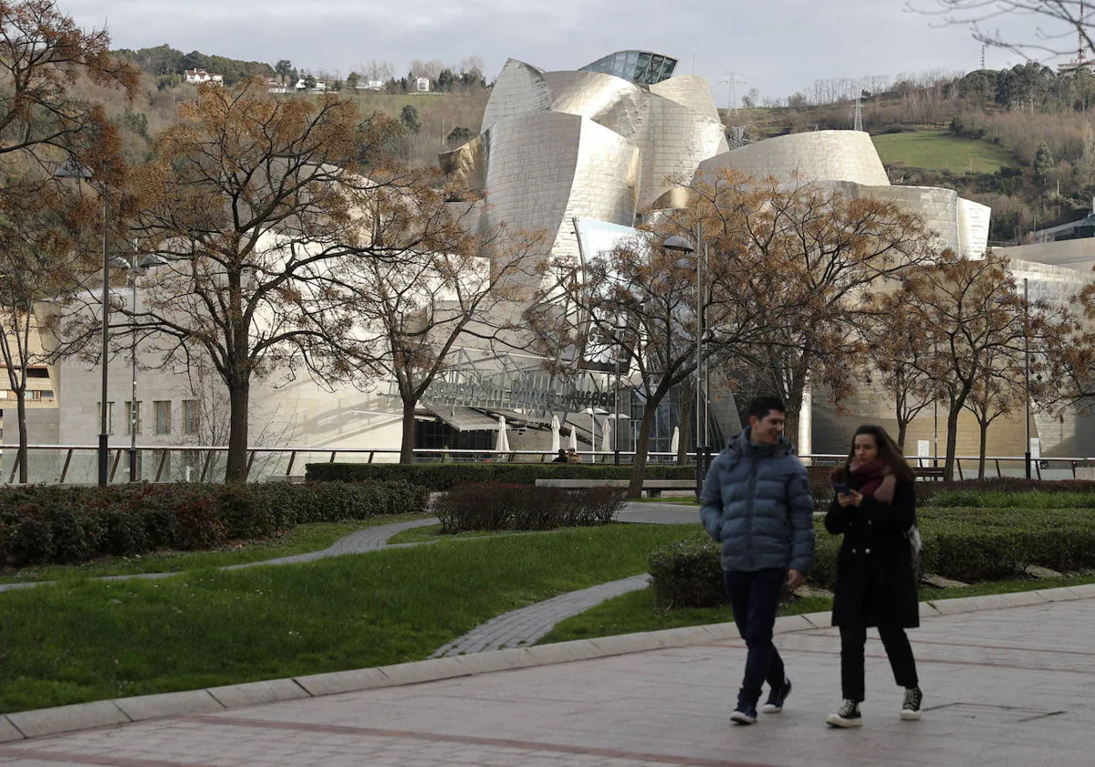 Una pareja pasea frente al Museo Guggenheim Bilbao