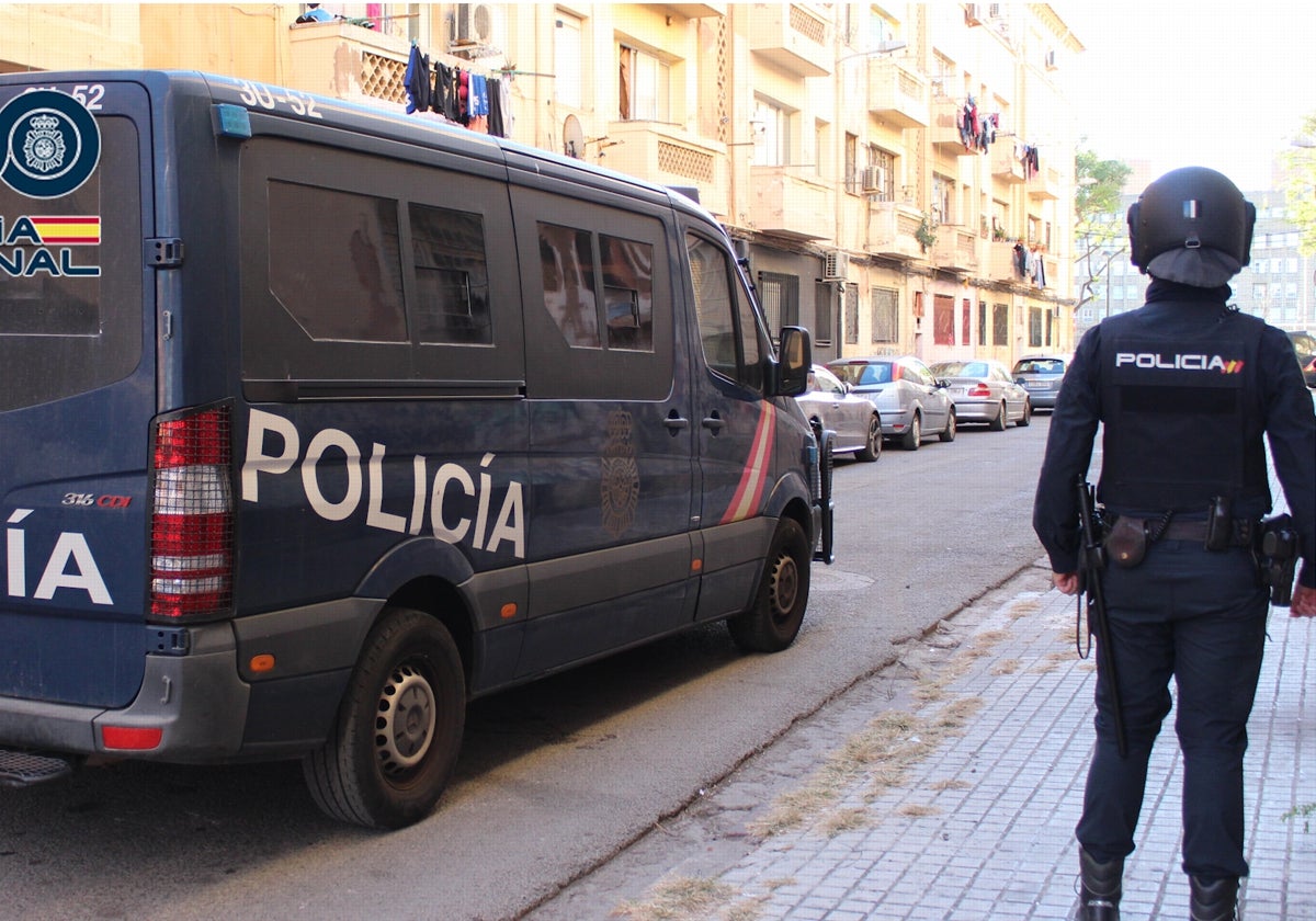 Un agente de la Policía Nacional junto a un furgón.