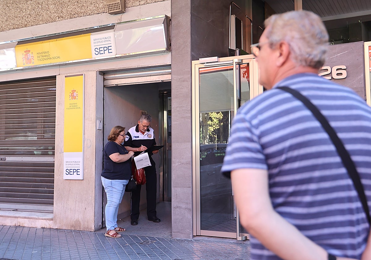 Una persona consulta en la puerta de una oficina de Empleo en Córdoba este verano