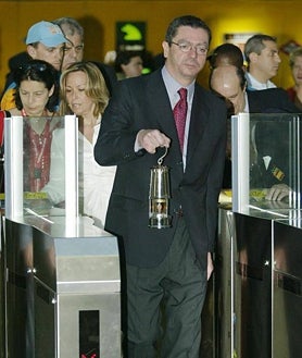 Imagen secundaria 2 - Arriba, Álvarez del Manzano, corriendo con la antorcha olímpica por Madrid en 1992. Abajo, izq., los entonces príncipes Felipe y Letizia encienden el pebetero en Madrid. Dcha, Ruiz-Gallardón entrando al Metro con el farolillo de la llama olímpica