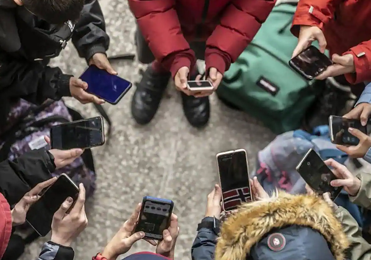 Varios jóvenes con su teléfonos móviles