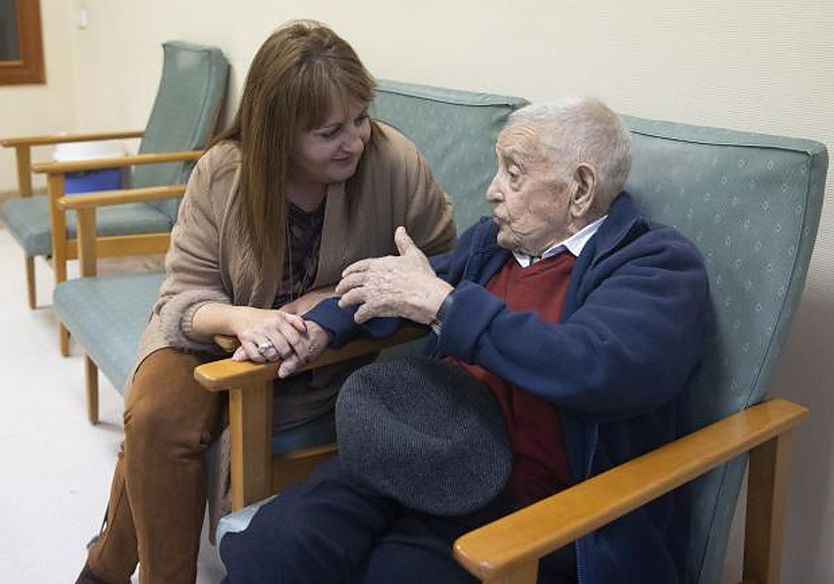 Una voluntaria de una fundación conversa con una persona mayor