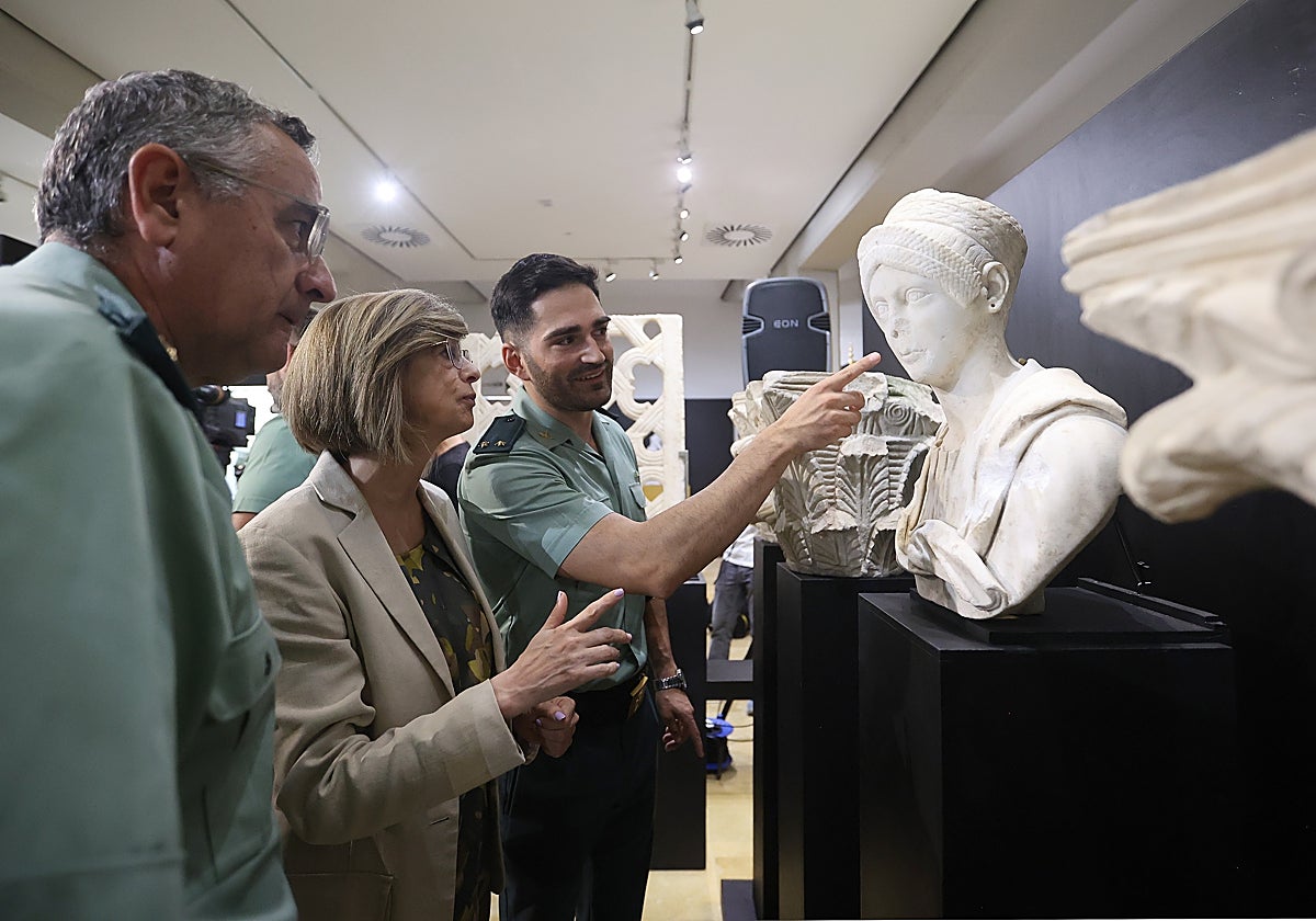 La exdirectora del Museo Arqueológico muestra unas piezas a dos agentes del la Guardia Civil