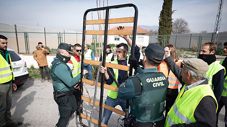 Uno de los detenidos, con el somier que intentó utilizar como ariete para llegar a la carretera