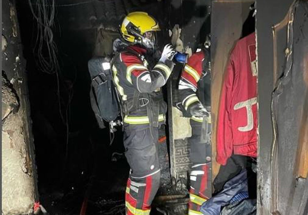 Bomberos inspeccionando la vivienda tras el incendio