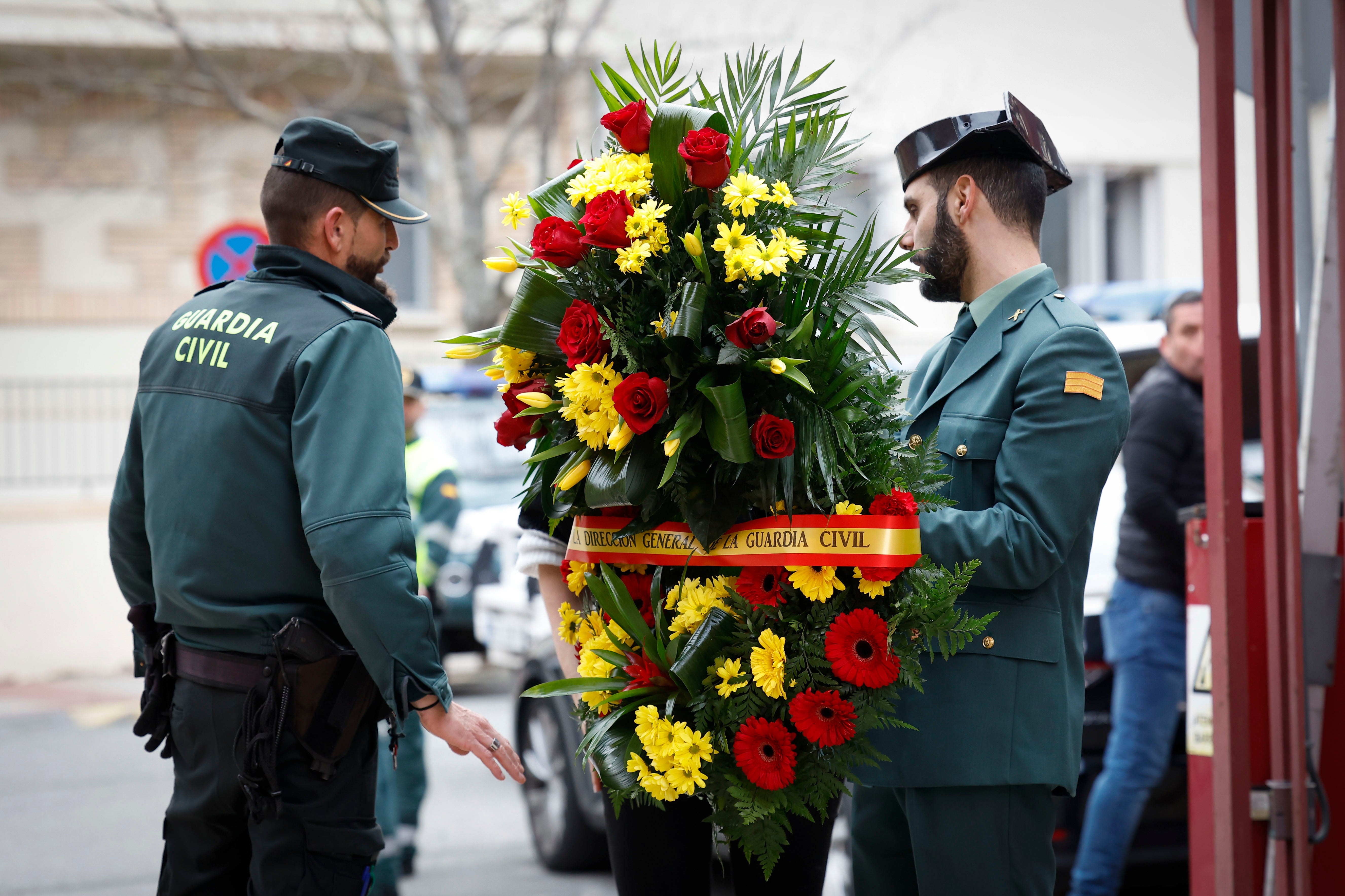 Unos agentes portan un ramo de flores en la comandancia de la Guardia Civil de Pamplona donde se ha abierto este domingo la capilla ardiente del guardia civil David Pérez Carracedo