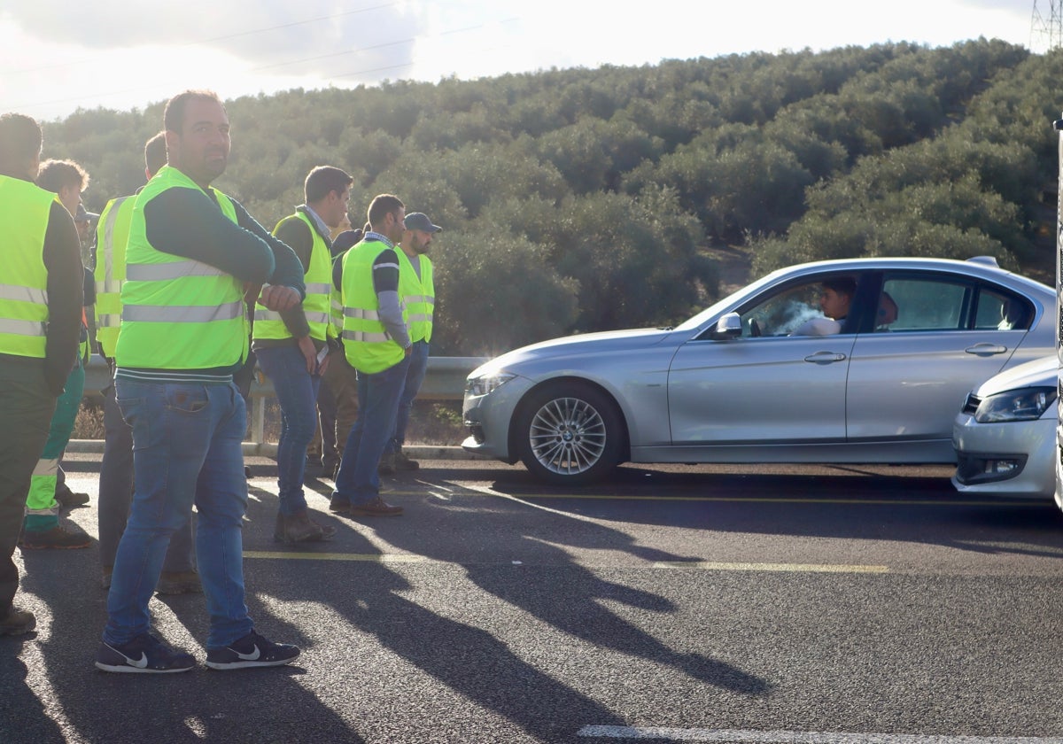 Un grupo de manifestantes impiden el paso de un coche en la A-318