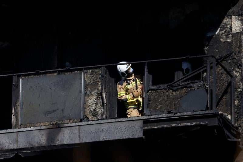 Un bombero inspeccionando el interior del edificio incendiado en Valencia
