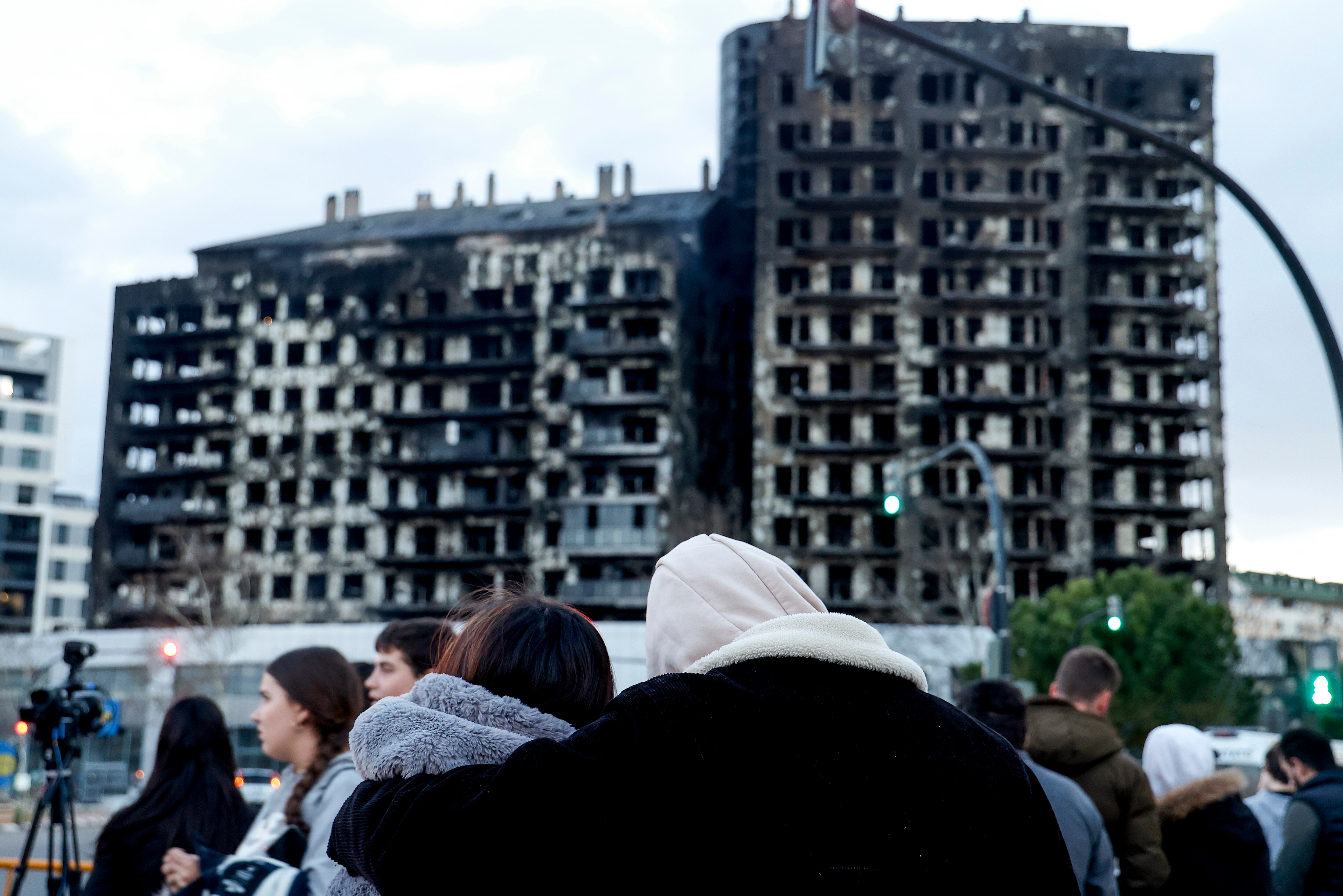 Una pareja observa abrazados el edificio incendiado en el barrio de Campanar de Valencia.