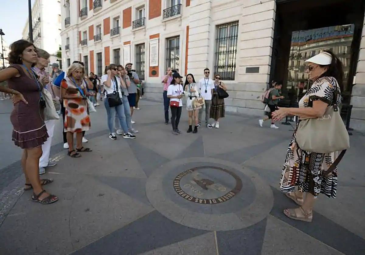 Turistas junto al Kilómetro Cero, en la Puerta del Sol