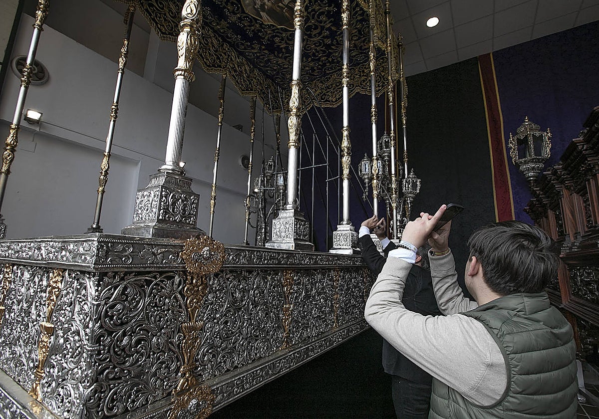 Dos hermanos del Caído fotografían las novedades del paso de palio, totalmente reformado