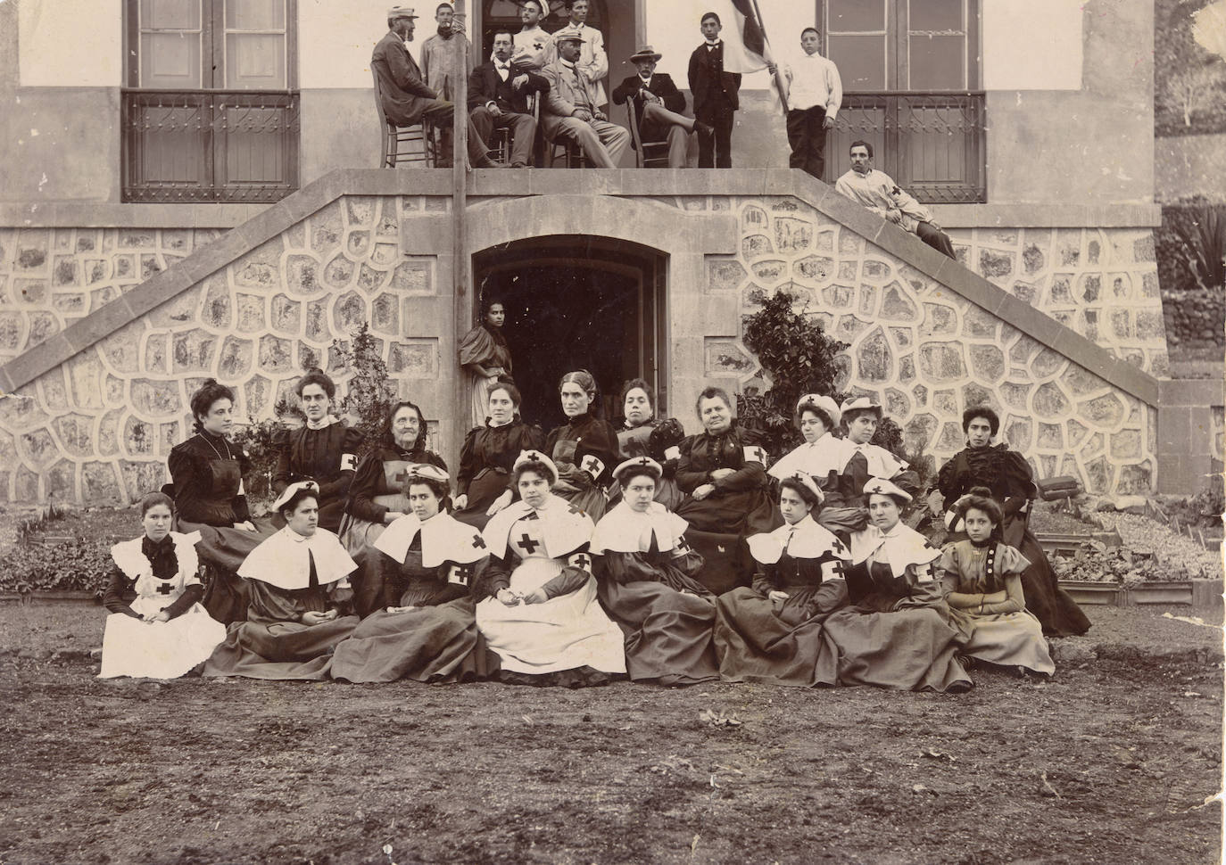 Caballeros y Damas de la Cruz Roja, delante del Sanatorio de repatriados. Santa Cruz de Tenerife (noviembre1898). Pura Veronesi, en primer plano, es la tercera por nuestra derecha. Fuente: https://www.fotosantiguascanarias.org/web/
