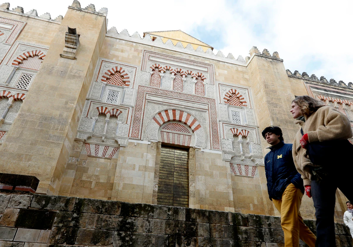 Dos turistas pasan delante de una de las puertas exteriores de la Mezquita-Catedral de Córdoba