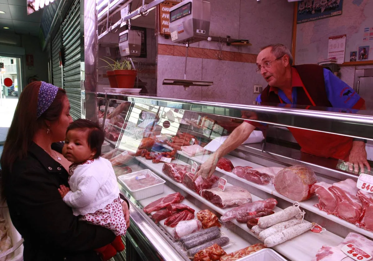 Un carnicero atiende a una mujer en un mercado