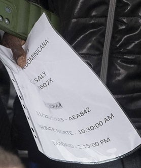 Imagen secundaria 2 - Decenas de inmigrantes en una de las salas de asilo del aeropuerto de Barajas; en las imágenes de la derecha, un hombre sostiene en un papel la ruta aérea de su grupo hasta alcanzar el campamento de emergencia de Alcalá de Henares.