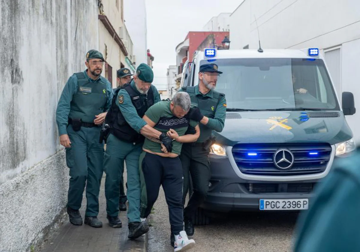 Guardias civiles, con uno de los detenidos por el asesinato de dos agentes en Barbate