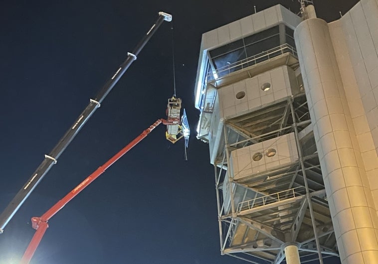 Personal especializado trabaja con una grúa para sustituir el cristal de la torre de control del aeropuerto de Alicante-Elche Miguel Hernández.