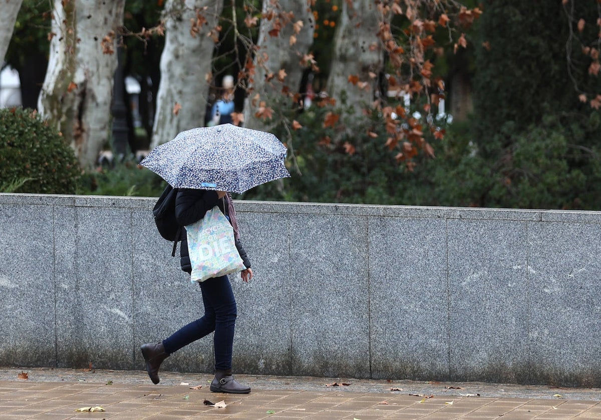 Una persona se refugia de la lluvia en Córdoba