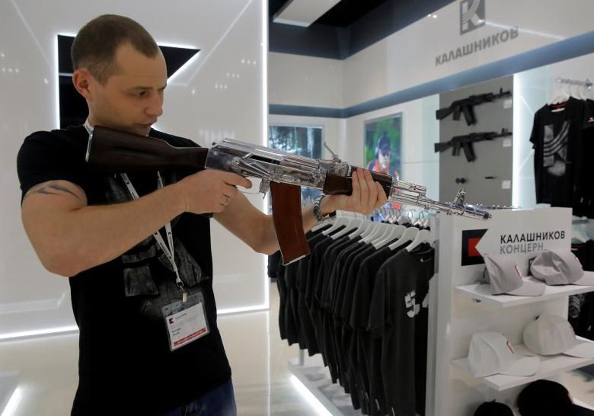 Un vendedor muestra cómo se usa un AK-47, en Moscú, en imagen de archivo