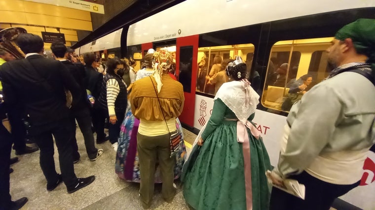 Falleros y músicos acceden al metro en Valencia