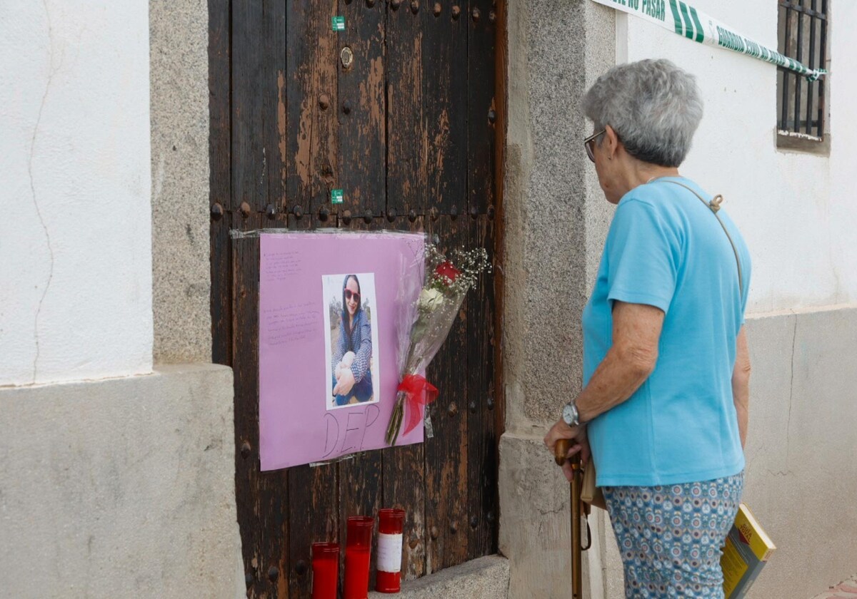 Una mujer mira la casa donde fue asesinada una mujer en Pozoblanco en agosto de 2023