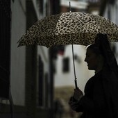 Una mujer vestida de mantilla con un paraguas