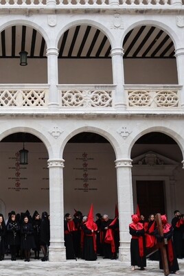 Cofrades y manolas en el interior del Palacio de Santa Cruz, en Valladolid, tras suspenderse la procesión