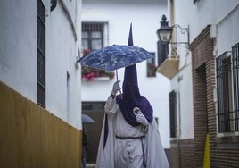 Un nazareno camina bajo un paraguas en una imagen de archivo