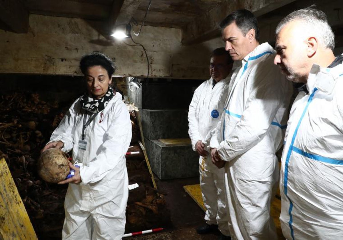 El presidente del Gobierno atiende las explicaciones de una técnica de las exhumaciones en el Valle de los Caídos